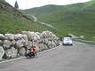 Tam vpravo dole stojí český autobus mnoho aut a motocyklů. Falešné passo di Sella